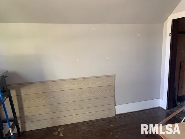 interior space featuring baseboards and wood finished floors
