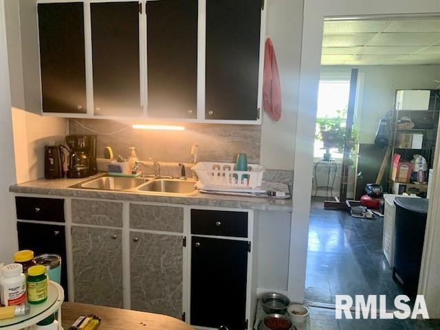 kitchen with light countertops, backsplash, and a sink