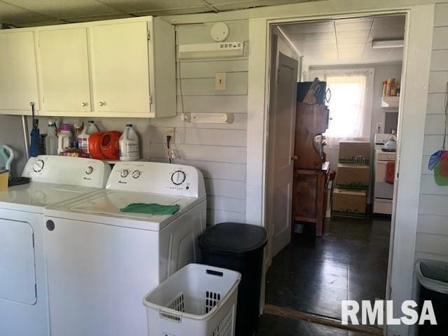 clothes washing area featuring washing machine and dryer and cabinet space