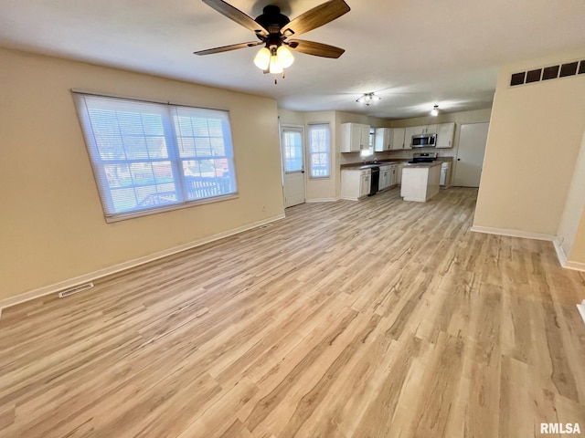 905 W Wind Rose Ln, Athens, IL 62613 - unfurnished living room with visible vents, light wood-type flooring, baseboards, and a ceiling fan