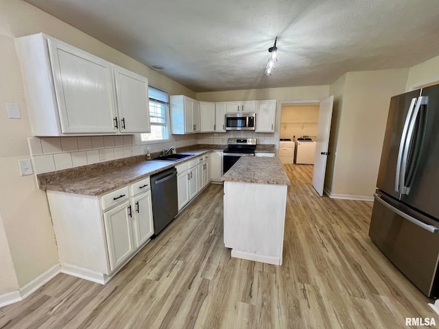 905 W Wind Rose Ln, Athens, IL 62613 - kitchen featuring light wood-type flooring, white cabinetry, backsplash, independent washer and dryer, and appliances with stainless steel finishes