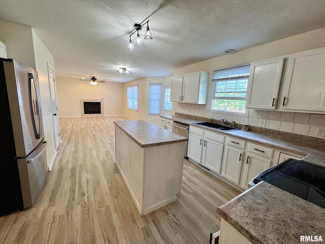 905 W Wind Rose Ln, Athens, IL 62613 - kitchen with a sink, light wood finished floors, a kitchen island, and stainless steel appliances