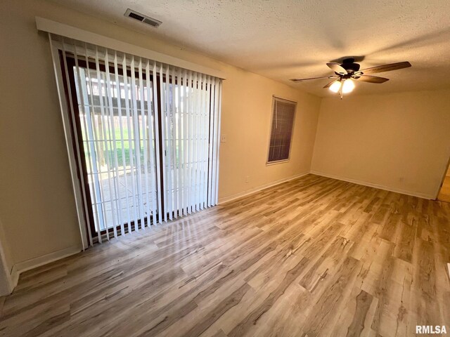 905 W Wind Rose Ln, Athens, IL 62613 - empty room with a textured ceiling, wood finished floors, ceiling fan, and visible vents