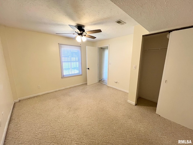 905 W Wind Rose Ln, Athens, IL 62613 - unfurnished bedroom with a textured ceiling, a closet, a ceiling fan, visible vents, and light carpet