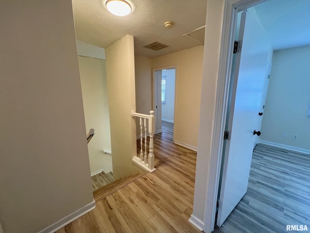 905 W Wind Rose Ln, Athens, IL 62613 - corridor with wood finished floors, visible vents, baseboards, and an upstairs landing
