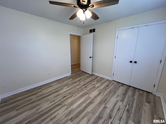905 W Wind Rose Ln, Athens, IL 62613 - unfurnished bedroom with a closet, light wood-type flooring, baseboards, a ceiling fan, and visible vents