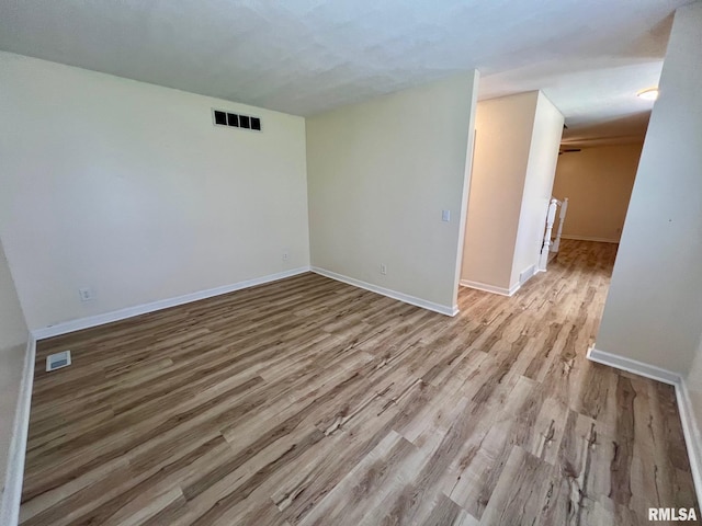 905 W Wind Rose Ln, Athens, IL 62613 - empty room with visible vents, baseboards, and wood finished floors