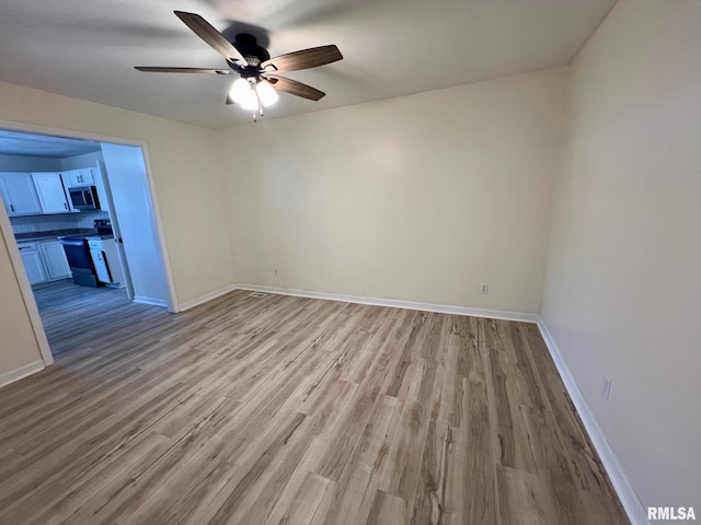 905 W Wind Rose Ln, Athens, IL 62613 - empty room featuring light wood-style floors, baseboards, and a ceiling fan