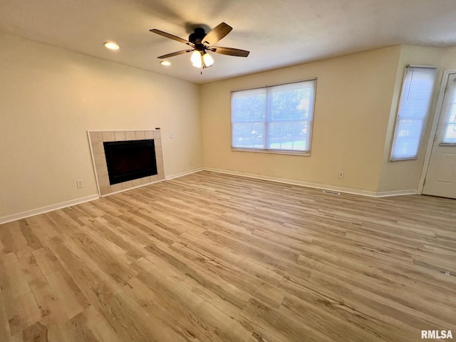 905 W Wind Rose Ln, Athens, IL 62613 - unfurnished living room with baseboards, a ceiling fan, recessed lighting, light wood-style flooring, and a tile fireplace