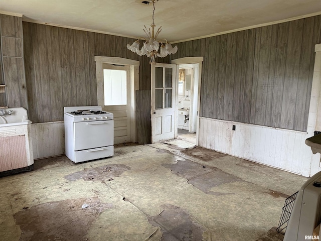 620 Jefferson St, Quincy, IL 62301 - kitchen with a chandelier, wooden walls, white gas stove, and washer / dryer