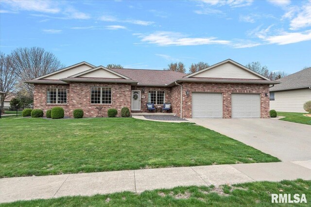 ranch-style home featuring an attached garage, concrete driveway, a front lawn, and brick siding