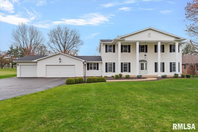 neoclassical home featuring driveway, an attached garage, and a front lawn
