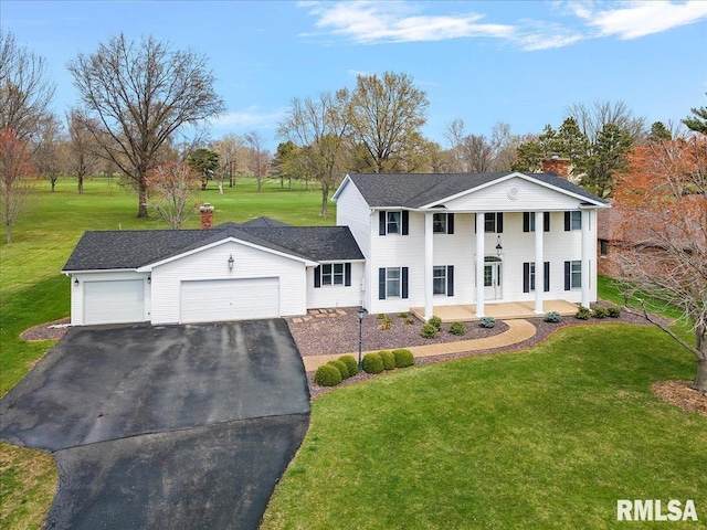 neoclassical home featuring a front lawn, covered porch, a garage, and aphalt driveway