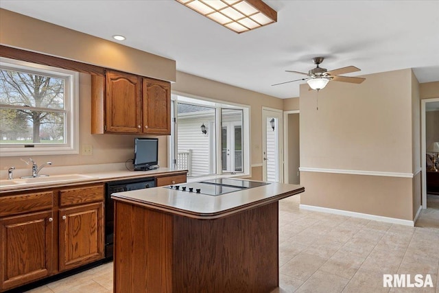kitchen with black appliances, brown cabinetry, a center island, and a sink