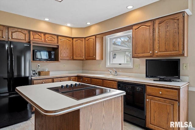 kitchen featuring a sink, black appliances, and brown cabinets