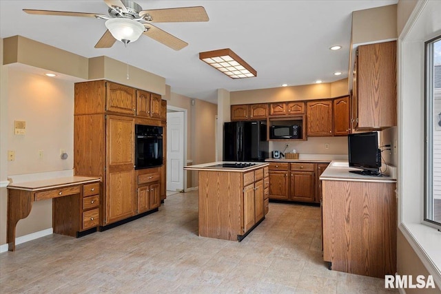 kitchen featuring a center island, brown cabinets, light countertops, and black appliances