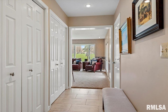 hallway featuring light carpet, recessed lighting, light tile patterned floors, and french doors