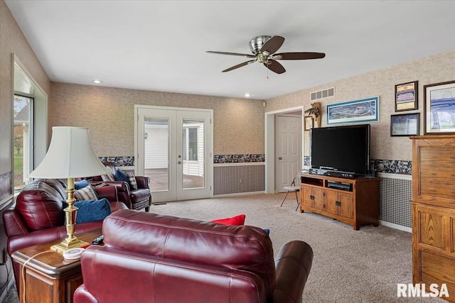 living room featuring visible vents, ceiling fan, wallpapered walls, french doors, and light colored carpet