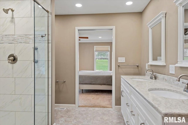 ensuite bathroom with a shower stall, recessed lighting, baseboards, and a sink