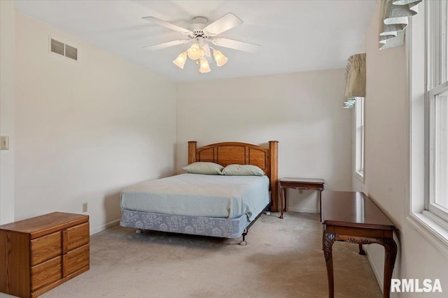 bedroom with visible vents, baseboards, ceiling fan, and light carpet