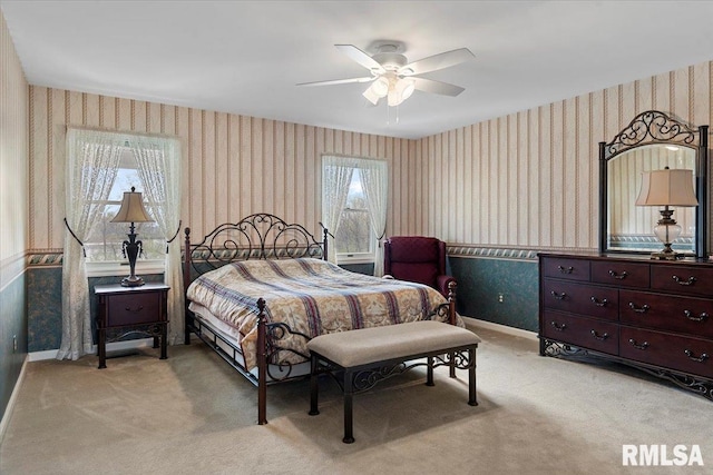 bedroom with baseboards, light colored carpet, wallpapered walls, and ceiling fan