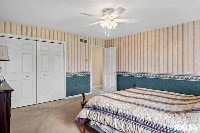 carpeted bedroom featuring visible vents, baseboards, a closet, a ceiling fan, and wallpapered walls