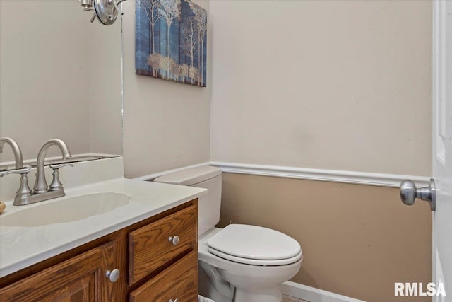 half bathroom featuring toilet and vanity
