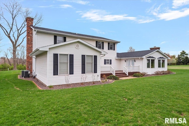 view of front of home with central AC unit, a wooden deck, a chimney, and a front lawn