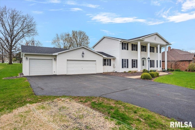 neoclassical home featuring a front yard, an attached garage, and driveway
