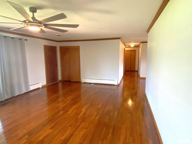 empty room featuring a baseboard radiator, ornamental molding, and wood finished floors