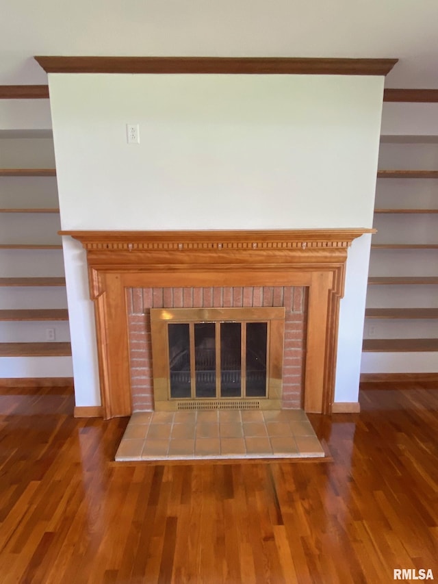 details featuring crown molding, wood finished floors, baseboards, and a glass covered fireplace