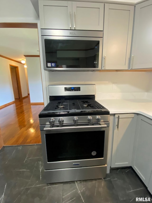 kitchen with light countertops, baseboards, and stainless steel appliances