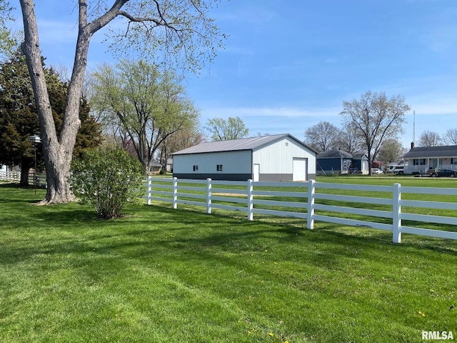 view of yard featuring an outbuilding, a garage, fence, and a pole building