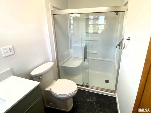 full bathroom featuring toilet, marble finish floor, a stall shower, and vanity