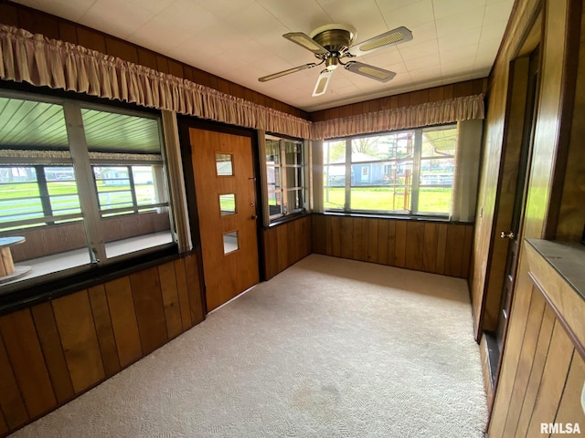 unfurnished sunroom with wood walls and carpet flooring