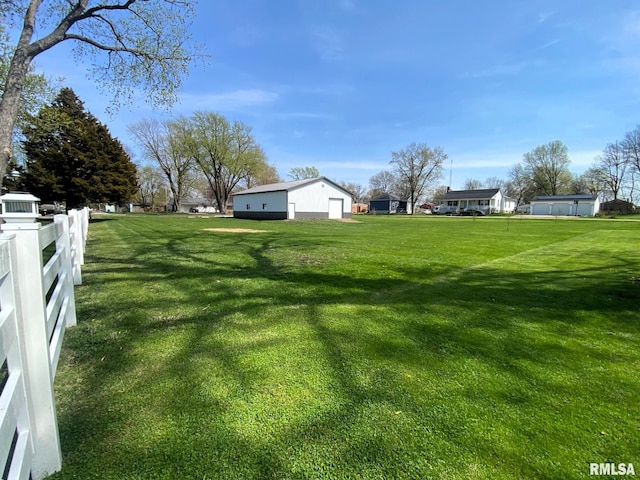 view of yard with a detached garage and fence