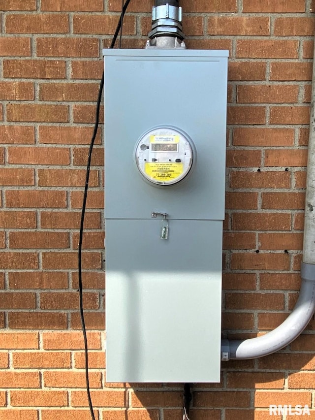 exterior space with brick siding, a wood stove, and electric meter