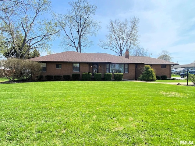ranch-style home with a chimney, a front lawn, and brick siding