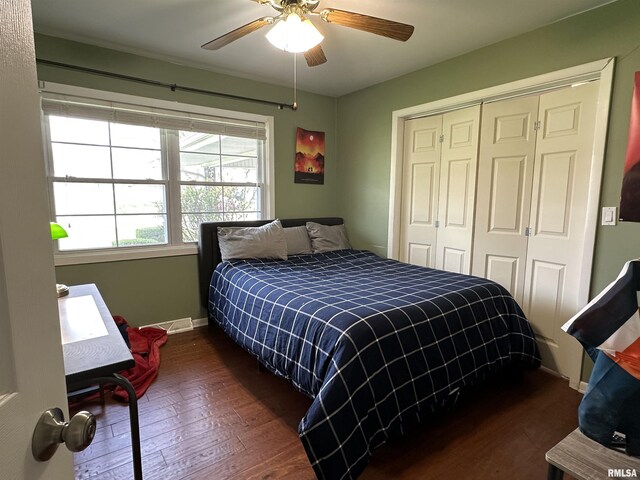 bedroom with baseboards, dark wood-type flooring, a closet, and a ceiling fan