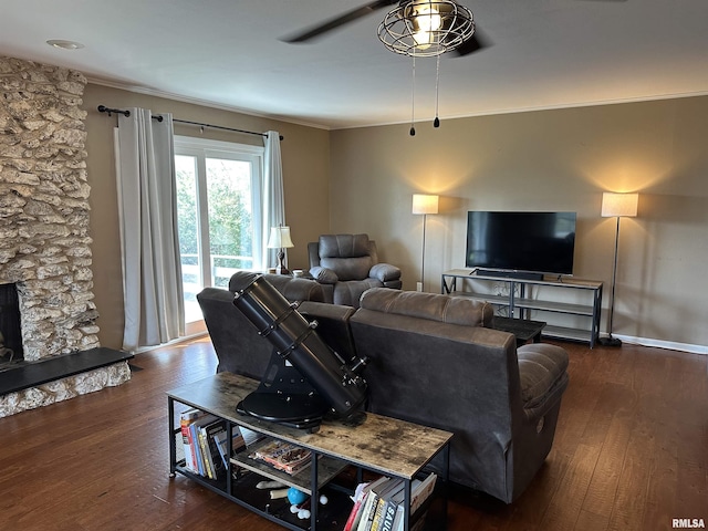 living room with ornamental molding, baseboards, a ceiling fan, and wood finished floors