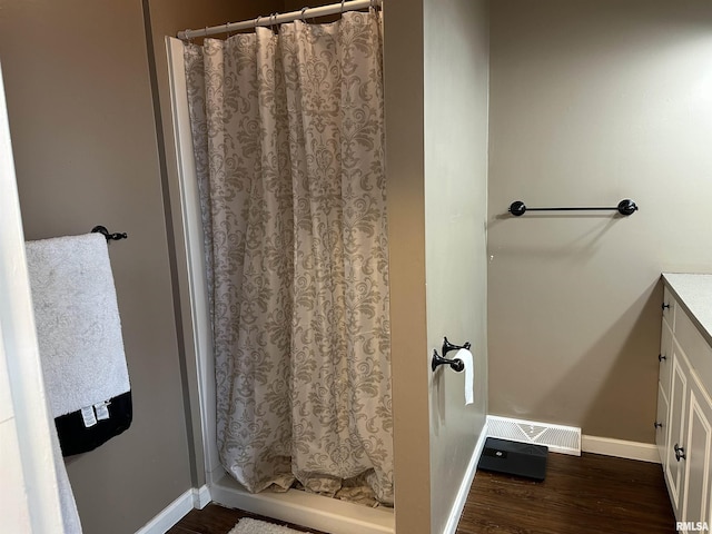 full bathroom featuring wood finished floors, baseboards, visible vents, and a shower with shower curtain