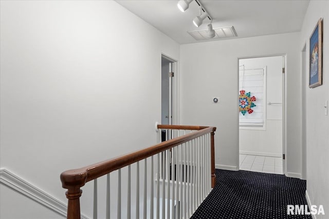 hall with visible vents, baseboards, an upstairs landing, carpet floors, and tile patterned flooring