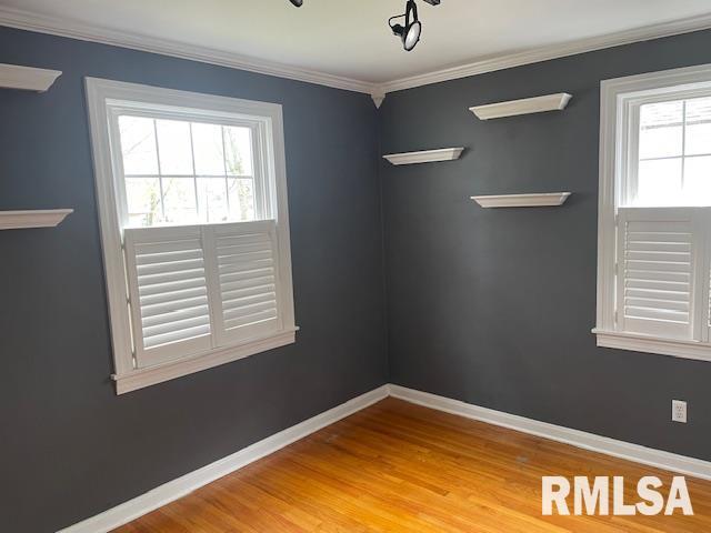 empty room featuring plenty of natural light, baseboards, and wood finished floors