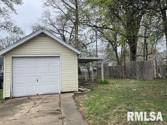 detached garage featuring fence and concrete driveway