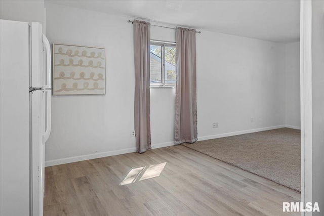 spare room with wood finished floors and baseboards