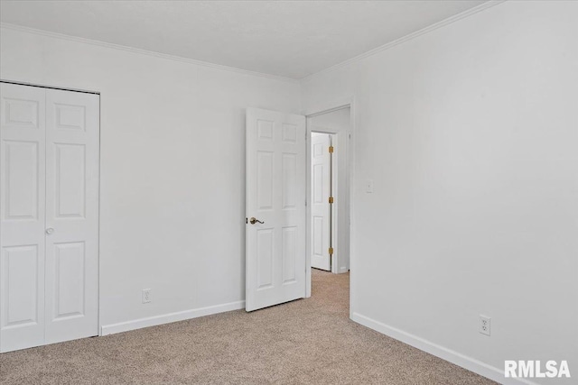 unfurnished bedroom featuring light carpet, a closet, baseboards, and ornamental molding