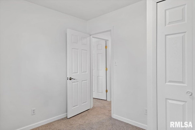 unfurnished bedroom with baseboards and light carpet