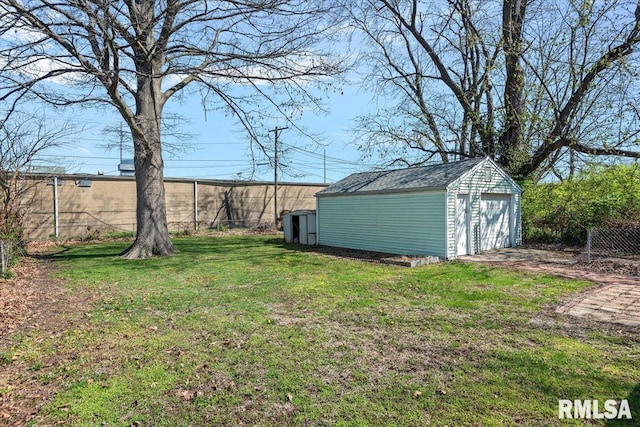 view of yard with a garage, an outdoor structure, and fence