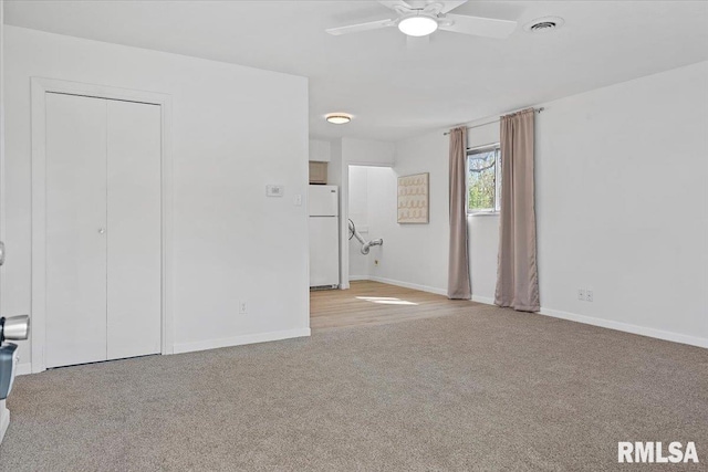unfurnished bedroom featuring a closet, baseboards, freestanding refrigerator, carpet floors, and visible vents
