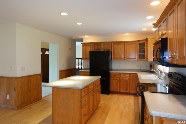 50 Hackberry Cir, Galesburg, IL 61401 - kitchen with black appliances, wainscoting, light wood-style floors, brown cabinets, and light countertops